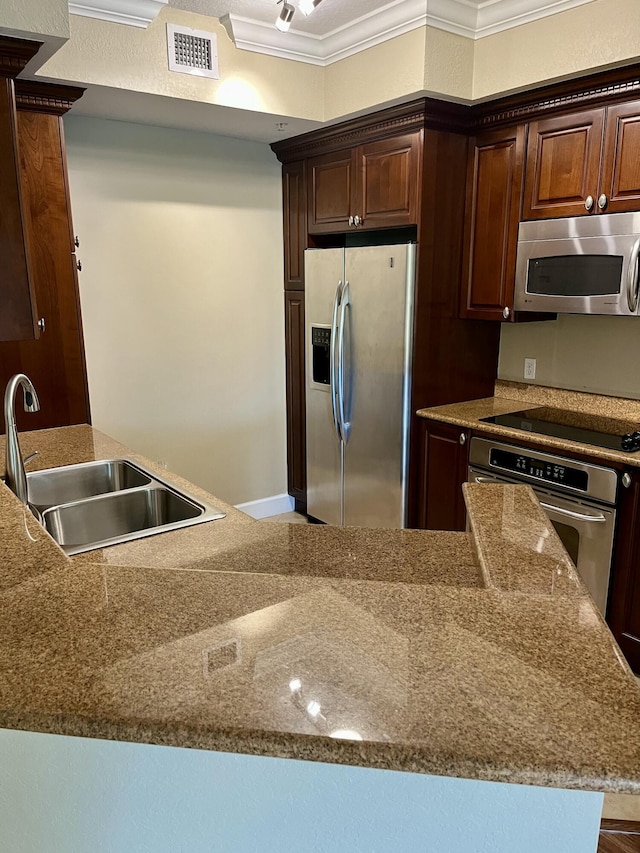 kitchen with dark brown cabinetry, visible vents, appliances with stainless steel finishes, ornamental molding, and a sink