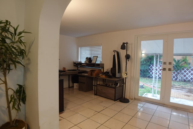 interior space featuring a wealth of natural light, arched walkways, french doors, and light tile patterned floors