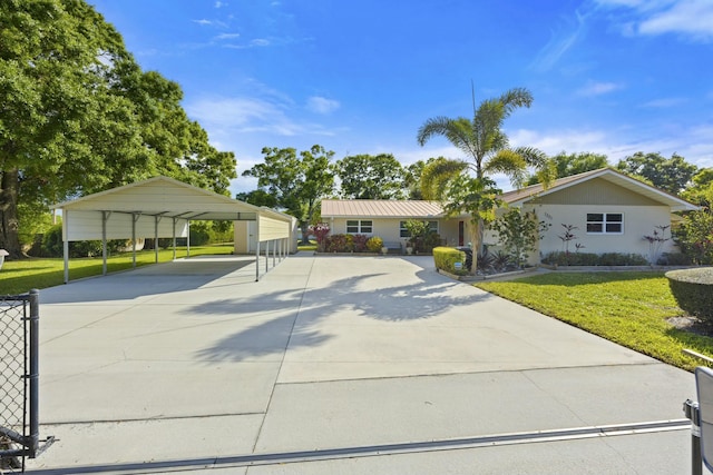 ranch-style home with a detached carport, driveway, and a front lawn