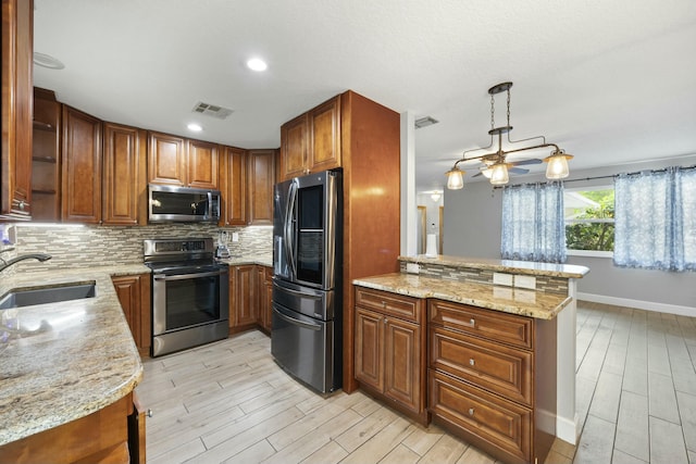 kitchen with a peninsula, a sink, appliances with stainless steel finishes, decorative backsplash, and brown cabinetry