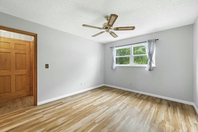 spare room with a ceiling fan, a textured ceiling, baseboards, and wood finished floors