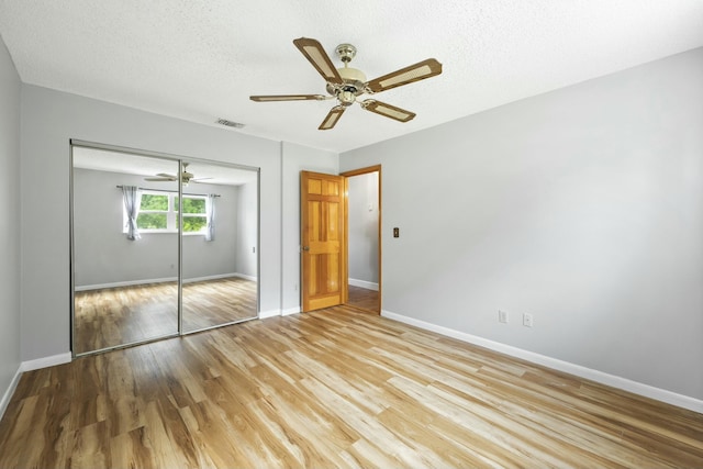 unfurnished bedroom featuring a closet, light wood-type flooring, and baseboards