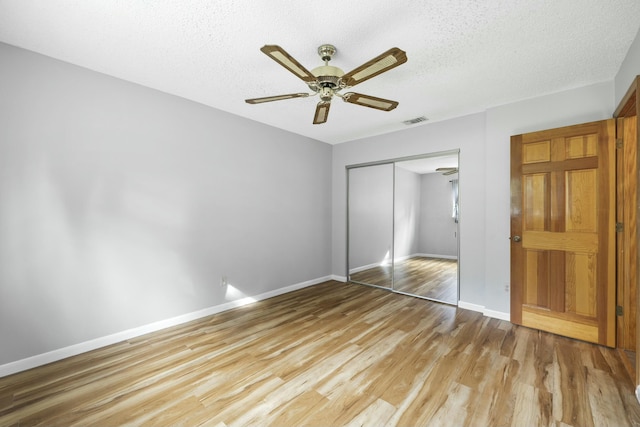 unfurnished bedroom featuring light wood finished floors, a closet, visible vents, and baseboards