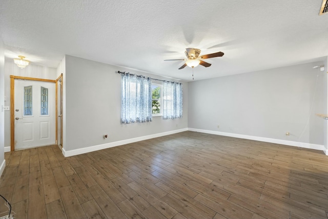 interior space featuring a textured ceiling, wood finished floors, a ceiling fan, and baseboards