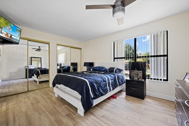 bedroom featuring ceiling fan, light wood-style flooring, baseboards, and two closets