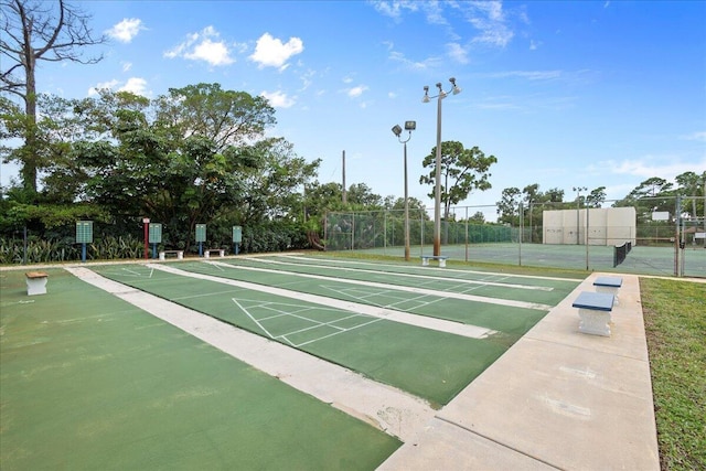 view of community featuring shuffleboard and fence