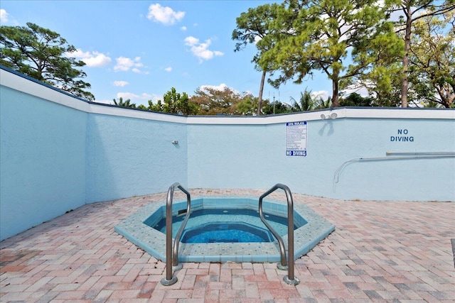 view of pool featuring a patio area and a hot tub