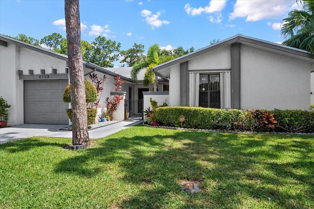 view of front of house featuring driveway, a front lawn, an attached garage, and stucco siding