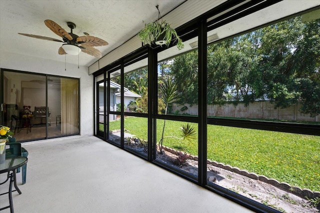 unfurnished sunroom with ceiling fan