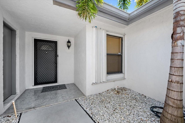 view of exterior entry with stucco siding