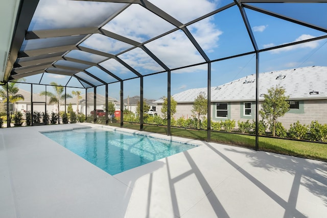 pool with glass enclosure and a patio area