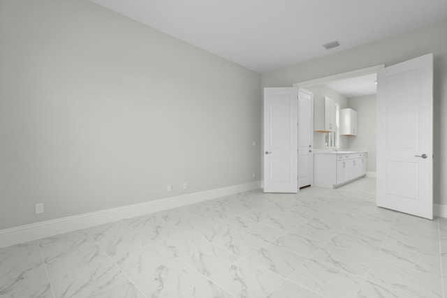 empty room featuring marble finish floor, visible vents, and baseboards