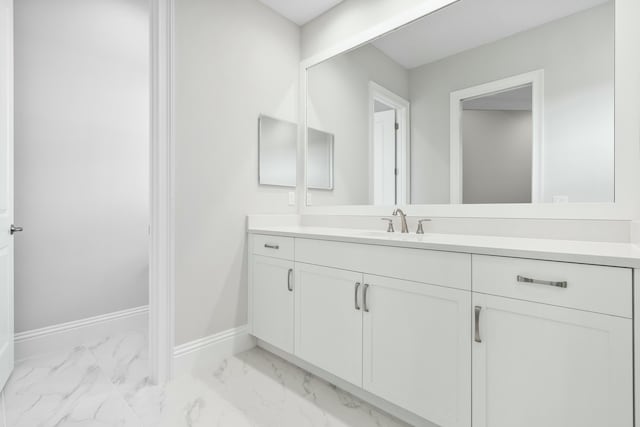 bathroom featuring marble finish floor, vanity, and baseboards