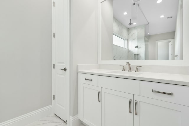 full bath with marble finish floor, a marble finish shower, visible vents, vanity, and baseboards