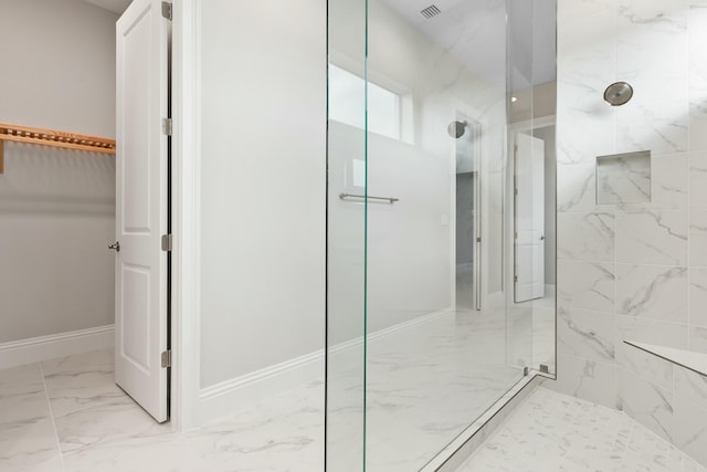 bathroom featuring a marble finish shower, visible vents, baseboards, marble finish floor, and a walk in closet