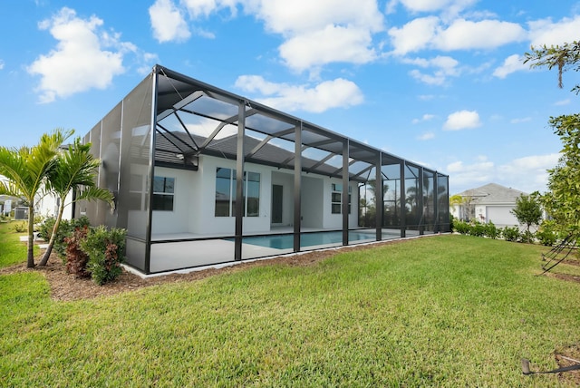 back of property with a yard, glass enclosure, and an outdoor pool