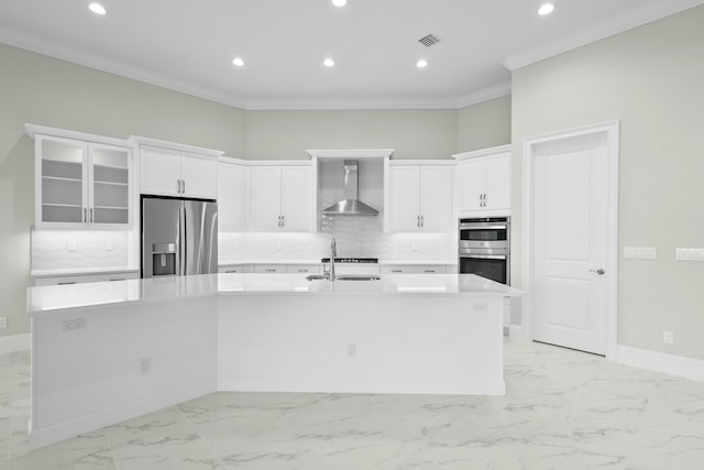 kitchen featuring visible vents, a spacious island, appliances with stainless steel finishes, light countertops, and wall chimney range hood