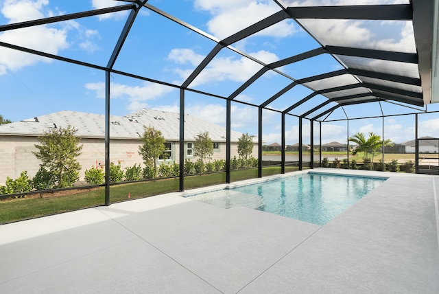 outdoor pool featuring glass enclosure and a patio