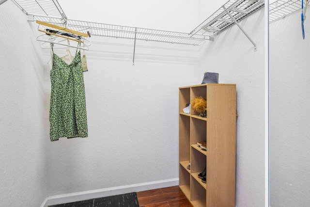 walk in closet with dark wood-type flooring