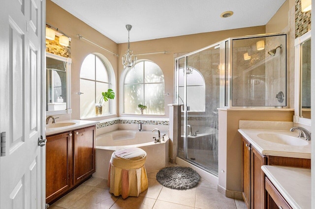 bathroom featuring a stall shower, tile patterned flooring, two vanities, and a sink