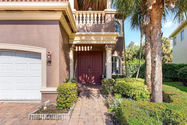 property entrance featuring a garage and stucco siding