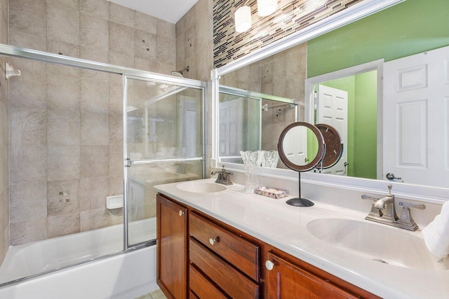 bathroom with double vanity, a sink, and bath / shower combo with glass door