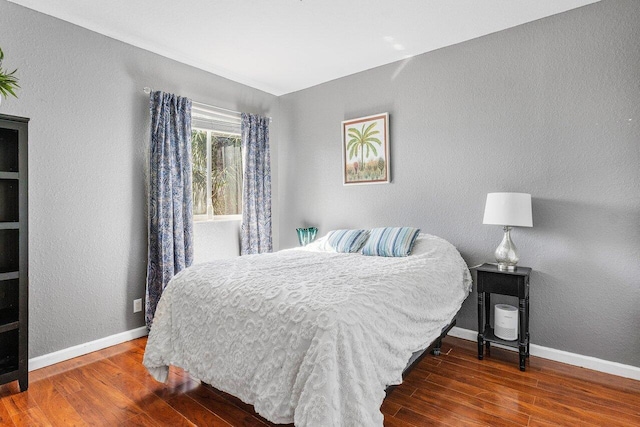 bedroom featuring wood finished floors and baseboards