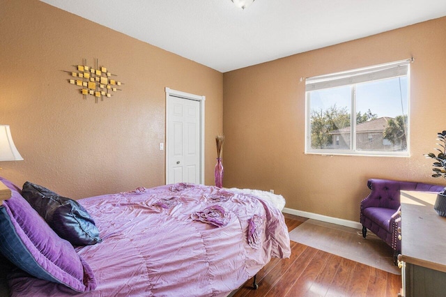 bedroom with baseboards and hardwood / wood-style flooring