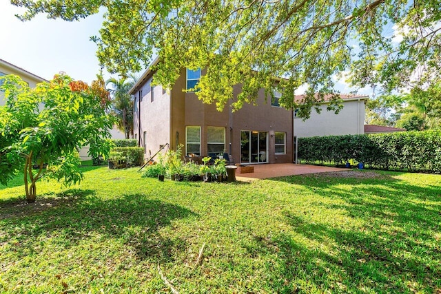 back of property featuring a patio area, a lawn, and stucco siding