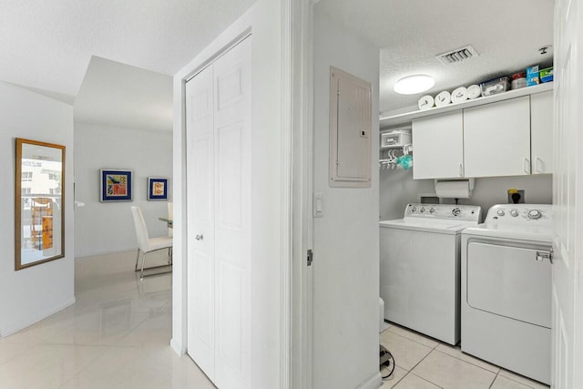 laundry area with cabinet space, electric panel, visible vents, washer and clothes dryer, and a textured ceiling