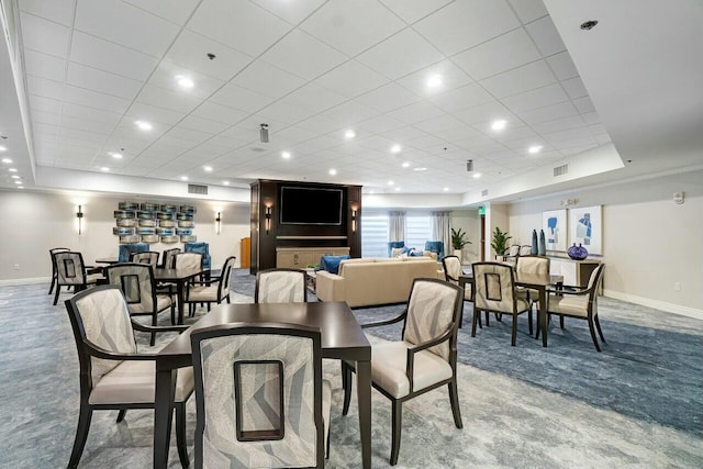 dining space featuring visible vents, a raised ceiling, and light colored carpet