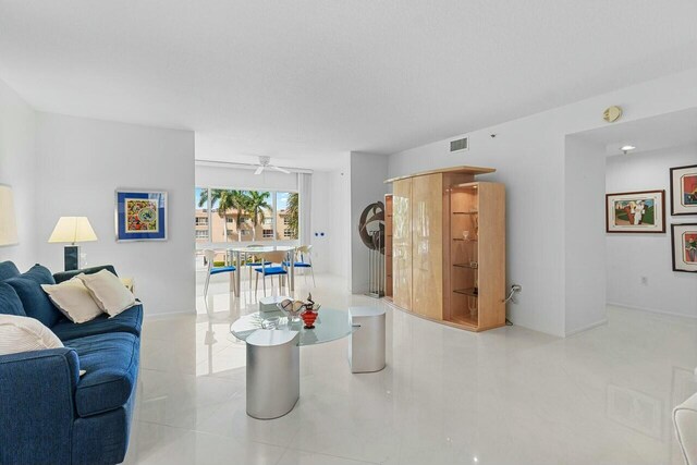 living room featuring ceiling fan and visible vents