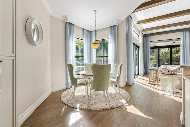 dining area with beamed ceiling, plenty of natural light, hardwood / wood-style flooring, and baseboards