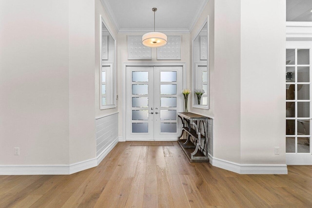 entryway featuring baseboards, wood finished floors, crown molding, and french doors