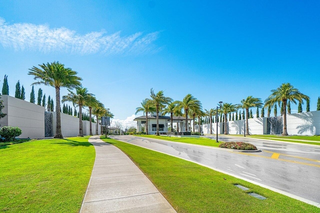 view of property's community featuring fence and a lawn