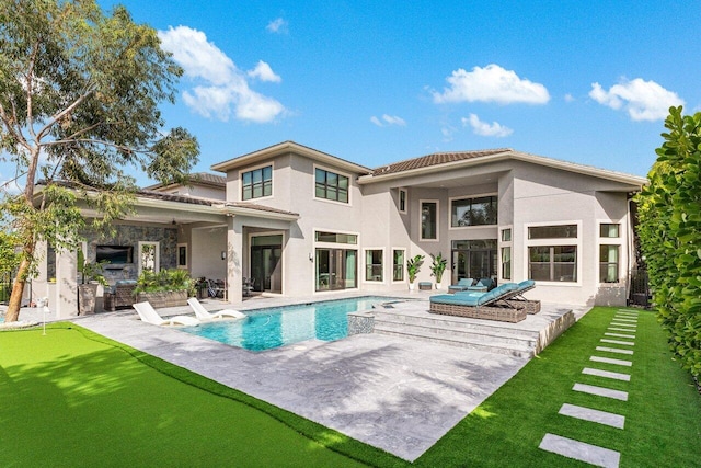 back of house with stucco siding, an outdoor pool, and a patio