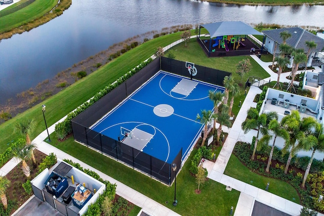 view of basketball court with a water view, community basketball court, and fence