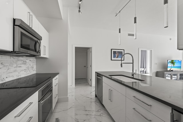 kitchen with marble finish floor, stainless steel appliances, dark countertops, backsplash, and a sink