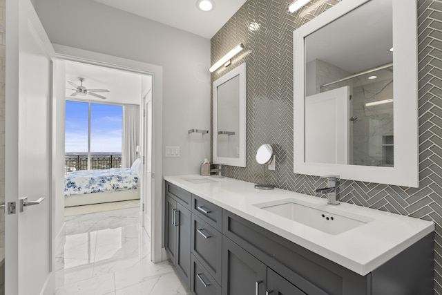 ensuite bathroom with marble finish floor, ensuite bath, tile walls, and a sink