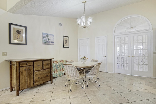 dining area featuring visible vents, a textured ceiling, french doors, a chandelier, and light tile patterned flooring