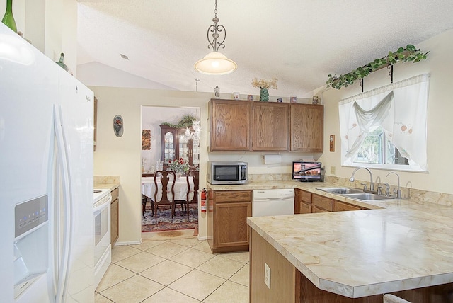 kitchen featuring a peninsula, white appliances, a sink, vaulted ceiling, and light countertops