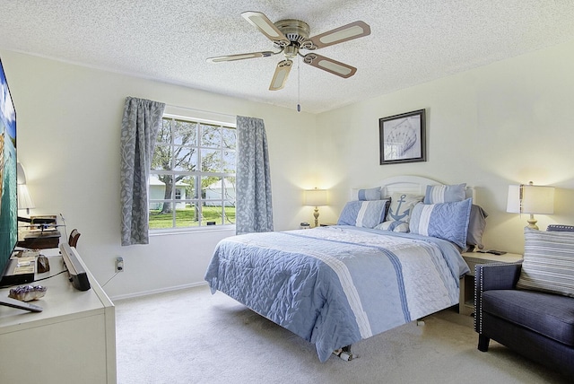 bedroom with carpet floors, ceiling fan, a textured ceiling, and baseboards