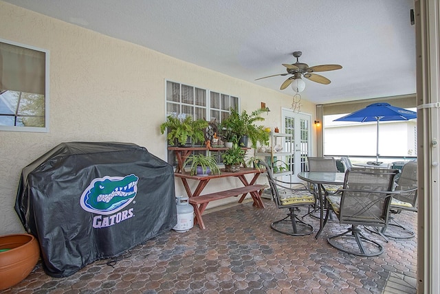 sunroom featuring french doors and a ceiling fan