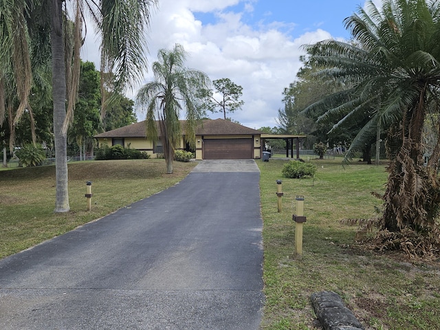 single story home with an attached garage, aphalt driveway, and a front yard