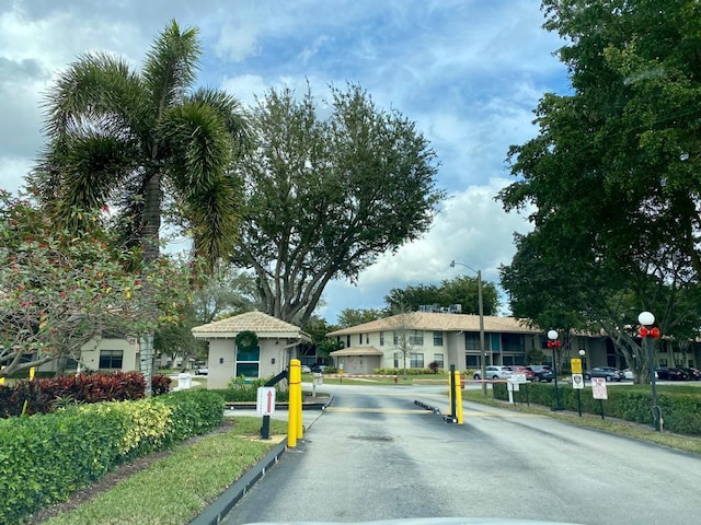 view of street with street lighting, traffic signs, a gated entry, and a speed bump