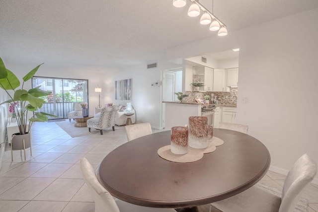 9785 Pineapple Tree Dr Unit 103, Boynton Beach, FL 33436 - dining space featuring light tile patterned floors and a textured ceiling