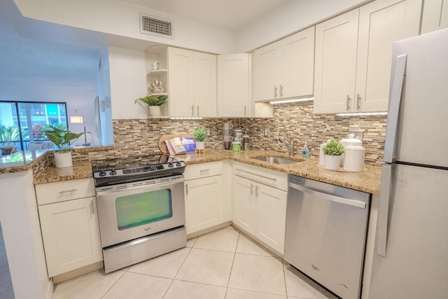 9785 Pineapple Tree Dr Unit 103, Boynton Beach, FL 33436 - kitchen featuring stainless steel appliances, open shelves, light tile patterned flooring, backsplash, and white cabinetry