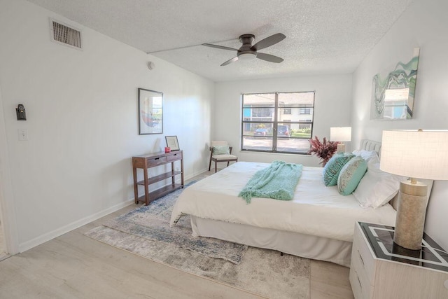 9785 Pineapple Tree Dr Unit 103, Boynton Beach, FL 33436 - bedroom featuring light wood-style floors, a textured ceiling, and ceiling fan