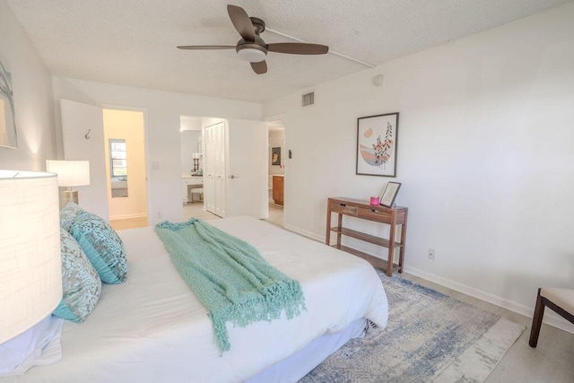 9785 Pineapple Tree Dr Unit 103, Boynton Beach, FL 33436 - bedroom featuring ensuite bathroom, a textured ceiling, and ceiling fan