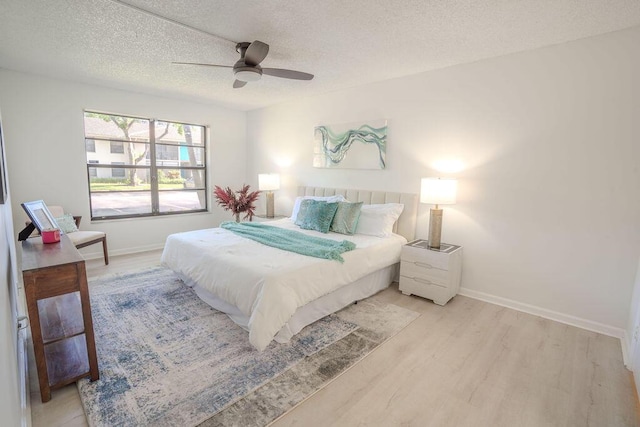 9785 Pineapple Tree Dr Unit 103, Boynton Beach, FL 33436 - bedroom with light wood finished floors, a textured ceiling, and ceiling fan